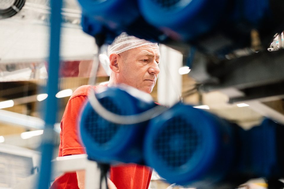 Mitarbeiter zwischen Anlagenteilen in der Produktion